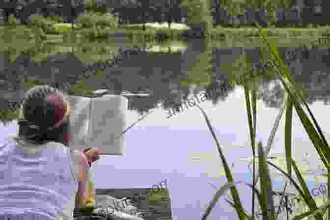 A Person Sitting By A Tranquil Lake, Reading The Book Diary Of A Young Naturalist